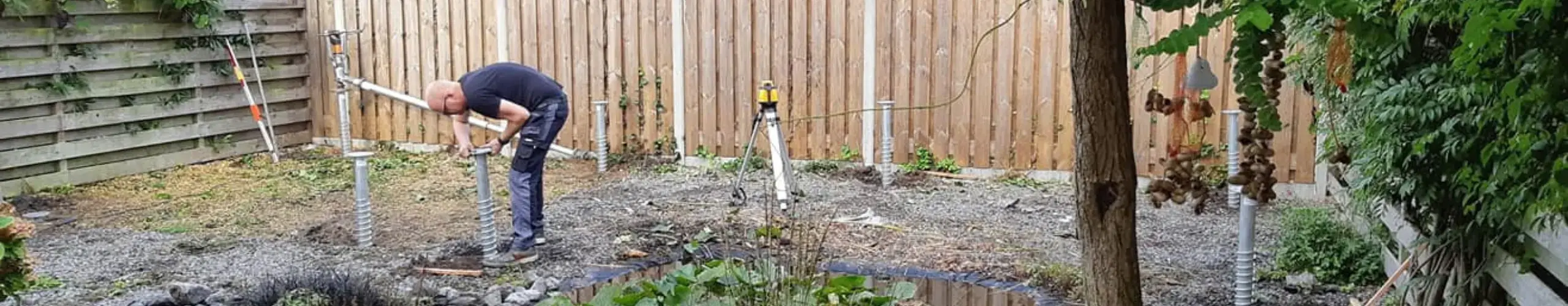Man plaatst schroeffunfering in tuin - GB Houtbouw