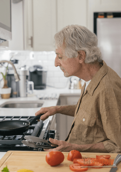 Oudere man zelfstandig aan het koken in een Mantelzorgwoning - GB Houtbouw Dronten