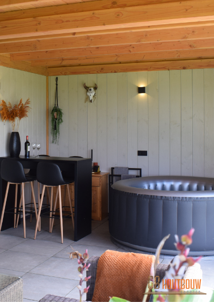 Sfeerfoto binnenzijde Douglas houten Veranda met een gezellig bartafel en een fraai opblaasjacuzzi om heerlijk te genieten van gezelligheid en ontspanning. - GB Houtbouw Dronten